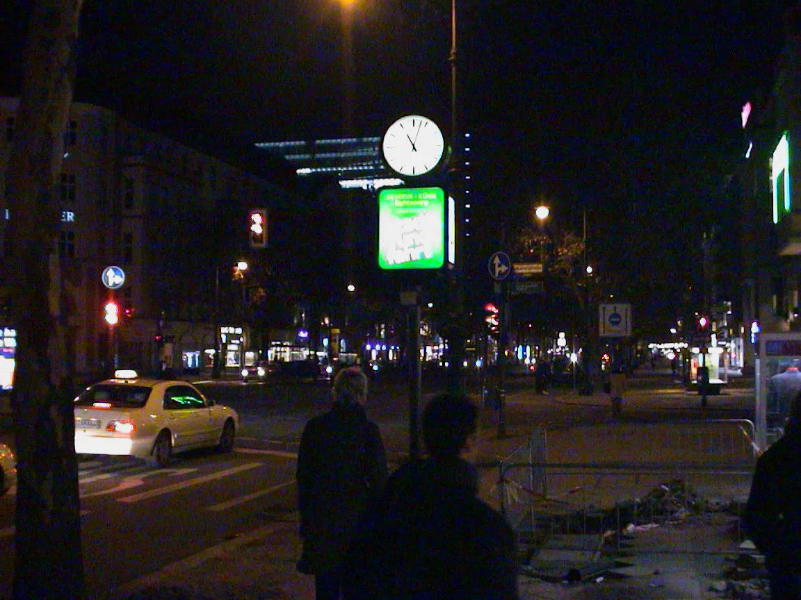 According to this clock on a pole it is three minutes past eleven.