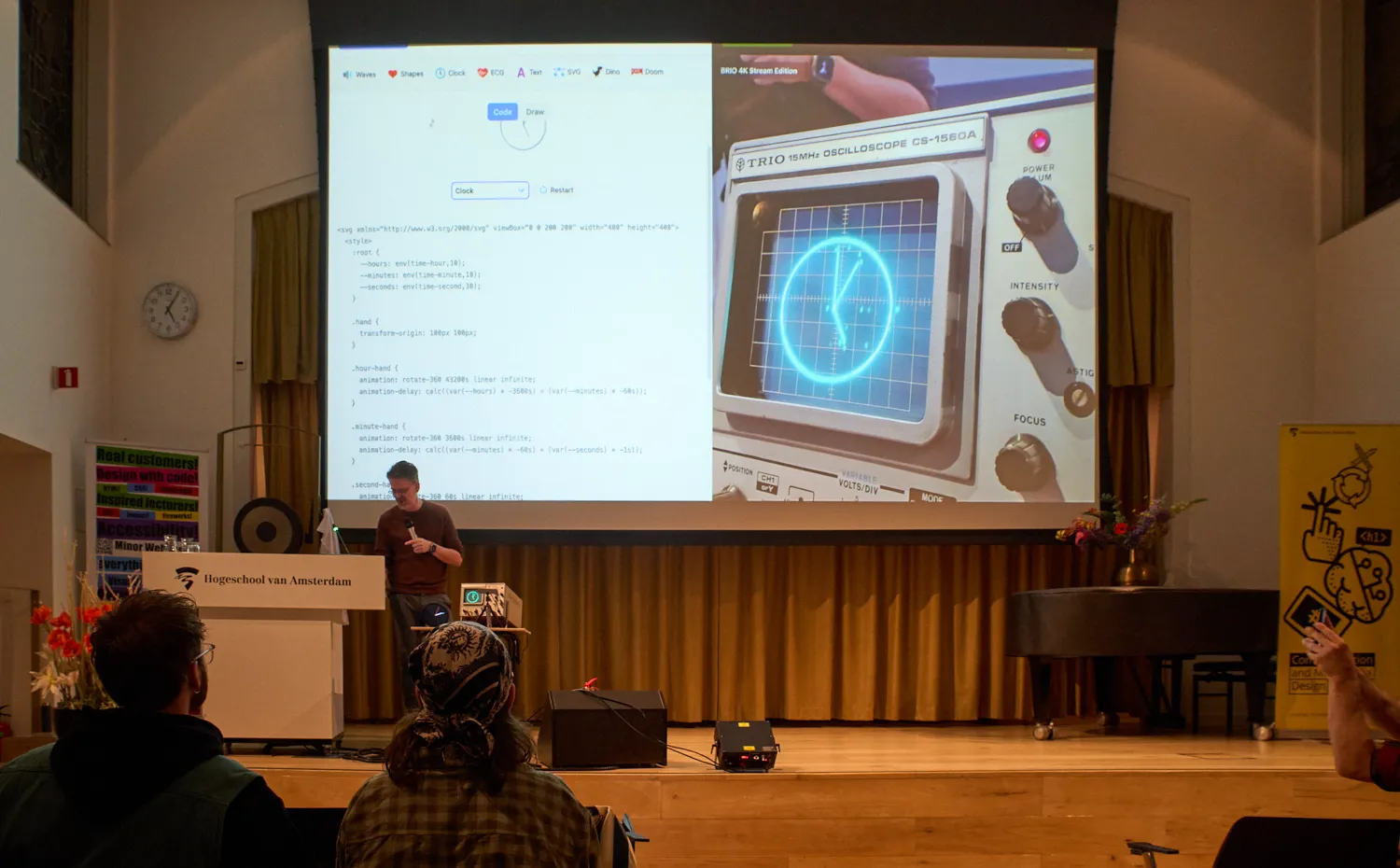 An osciloscope with a clock on it, shown on a big screen by someone behind a lectern